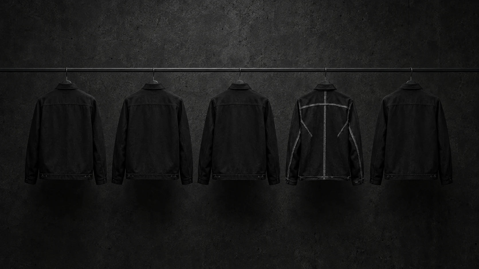 Five black jackets in a uniform row. The fourth is inside out, with pale exposed seams beneath an otherwise familiar silhouette.